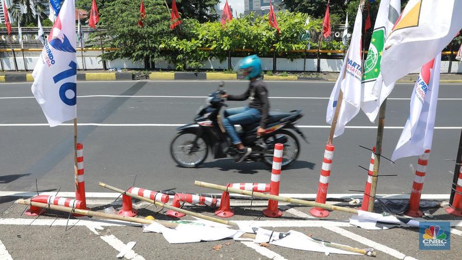 Kendaraan bermotor melintas di samping alat peraga kampanye (APK) pemilu 2024 yang terpasang di pembatas jalur sepeda (stick cone) di kawasan Menteng, Jakarta, Selasa (9/1/2024). Pemasangan APK Pemilu 2024 tersebut melanggar Peraturan KPU yang melarang pemasangan atribut partai atau caleg di fasilitas umum. (CNBC Indonesia/Muhammad Sabki)