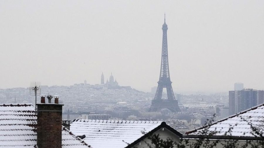 Menara Eiffel dan basilika Sacre Coeur, di kejauhan, terlihat Selasa, 9 Januari 2024 di Paris dengan suhu turun di bawah nol derajat Celcius. (AP Photo/Christophe Ena)