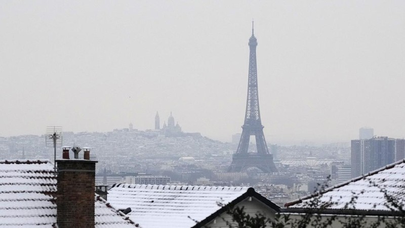 Orang-orang berjalan di gang-gang yang tertutup salju di Chateau de Versailles Selasa, 9 Januari 2024 di Versailles, sebelah barat Paris, di mana suhu turun di bawah nol derajat Celcius. (AP Photo/Christophe Ena)