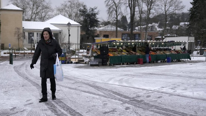 Orang-orang berjalan di gang-gang yang tertutup salju di Chateau de Versailles Selasa, 9 Januari 2024 di Versailles, sebelah barat Paris, di mana suhu turun di bawah nol derajat Celcius. (AP Photo/Christophe Ena)