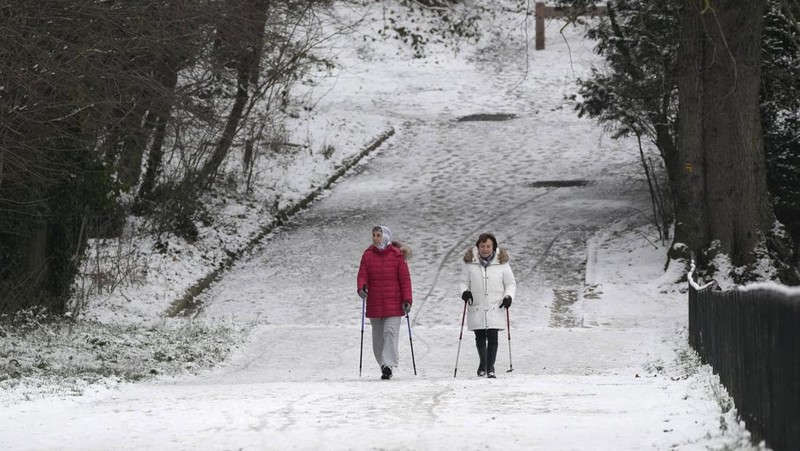 Orang-orang berjalan di gang-gang yang tertutup salju di Chateau de Versailles Selasa, 9 Januari 2024 di Versailles, sebelah barat Paris, di mana suhu turun di bawah nol derajat Celcius. (AP Photo/Christophe Ena)