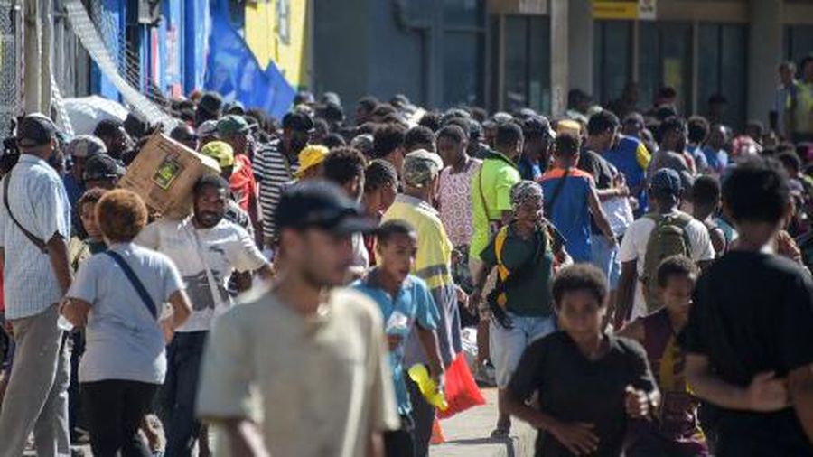 Orang-orang berkumpul di dekat sebuah gedung, di tengah laporan penjarahan dan pembakaran yang meluas ketika polisi dan sektor publik memprotes pemotongan gaji yang menurut para pejabat disebabkan oleh kesalahan administratif, di Port Moresby, Papua Nugini, 10 Januari 2024, dalam tangkapan layar yang diperoleh dari sebuah video. (Mackenzie Waide/via REUTERS)