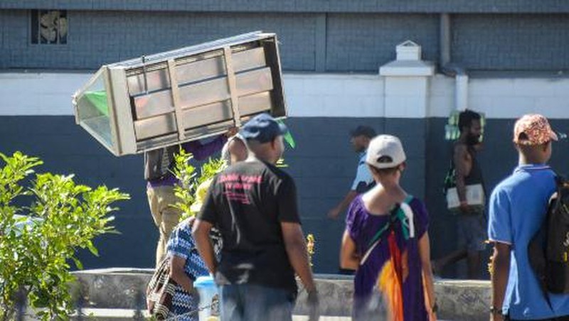 Orang-orang berkumpul di dekat sebuah gedung, di tengah laporan penjarahan dan pembakaran yang meluas ketika polisi dan sektor publik memprotes pemotongan gaji yang menurut para pejabat disebabkan oleh kesalahan administratif, di Port Moresby, Papua Nugini, 10 Januari 2024, dalam tangkapan layar yang diperoleh dari sebuah video. (Mackenzie Waide/via REUTERS)