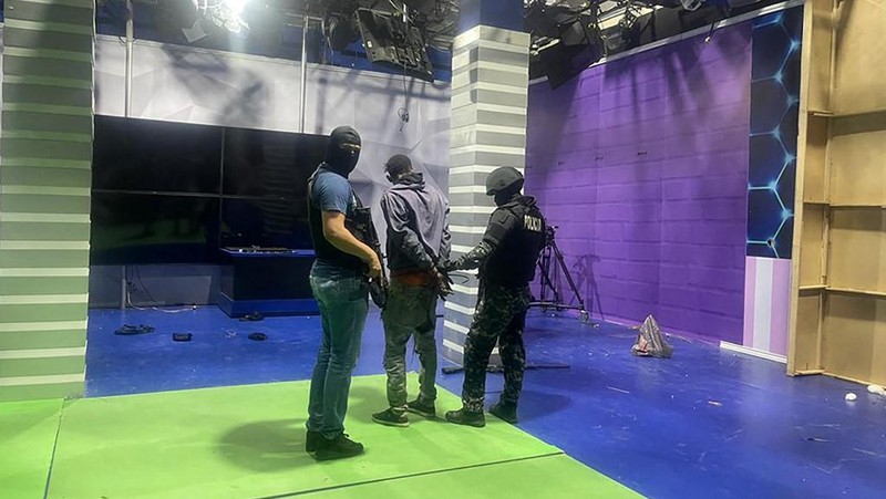 Petugas polisi menangkap salah satu pria bersenjata tak dikenal yang menyerbu ke dalam studio televisi milik negara TC saat siaran langsung, di Guayaquil, Ekuador, pada 9 Januari 2024, sehari setelah Presiden Ekuador Daniel Noboa mengumumkan keadaan darurat setelah melarikan diri dari penjara bos narco yang berbahaya. Suara tembakan terdengar di siaran langsung TV di Ekuador yang dilanda kekerasan ketika orang-orang bersenjata yang membawa senapan dan granat menyerbu studio tak lama setelah para gangster bersumpah akan melakukan 
