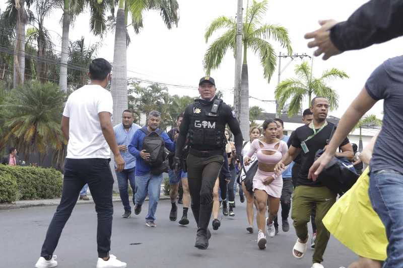 Petugas polisi menangkap salah satu pria bersenjata tak dikenal yang menyerbu ke dalam studio televisi milik negara TC saat siaran langsung, di Guayaquil, Ekuador, pada 9 Januari 2024, sehari setelah Presiden Ekuador Daniel Noboa mengumumkan keadaan darurat setelah melarikan diri dari penjara bos narco yang berbahaya. Suara tembakan terdengar di siaran langsung TV di Ekuador yang dilanda kekerasan ketika orang-orang bersenjata yang membawa senapan dan granat menyerbu studio tak lama setelah para gangster bersumpah akan melakukan 