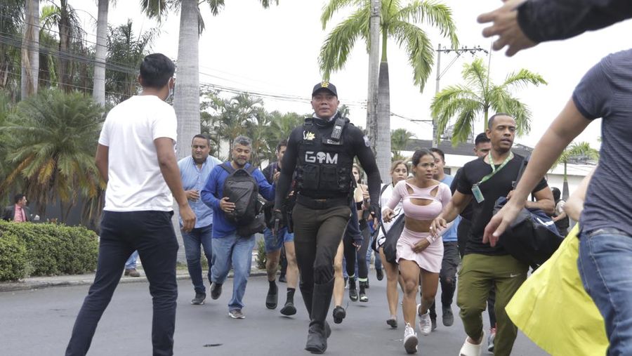Petugas polisi menangkap salah satu pria bersenjata tak dikenal yang menyerbu ke dalam studio televisi milik negara TC saat siaran langsung, di Guayaquil, Ekuador, pada 9 Januari 2024, sehari setelah Presiden Ekuador Daniel Noboa mengumumkan keadaan darurat setelah melarikan diri dari penjara bos narco yang berbahaya. Suara tembakan terdengar di siaran langsung TV di Ekuador yang dilanda kekerasan ketika orang-orang bersenjata yang membawa senapan dan granat menyerbu studio tak lama setelah para gangster bersumpah akan melakukan 