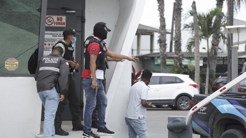 Petugas polisi menangkap salah satu pria bersenjata tak dikenal yang menyerbu ke dalam studio televisi milik negara TC saat siaran langsung, di Guayaquil, Ekuador, pada 9 Januari 2024, sehari setelah Presiden Ekuador Daniel Noboa mengumumkan keadaan darurat setelah melarikan diri dari penjara bos narco yang berbahaya. Suara tembakan terdengar di siaran langsung TV di Ekuador yang dilanda kekerasan ketika orang-orang bersenjata yang membawa senapan dan granat menyerbu studio tak lama setelah para gangster bersumpah akan melakukan 