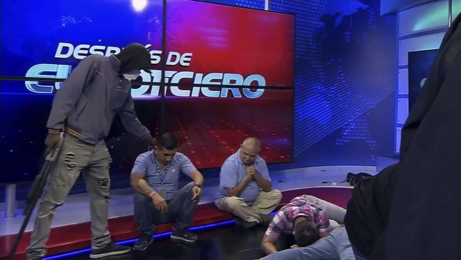 Petugas polisi menangkap salah satu pria bersenjata tak dikenal yang menyerbu ke dalam studio televisi milik negara TC saat siaran langsung, di Guayaquil, Ekuador, pada 9 Januari 2024, sehari setelah Presiden Ekuador Daniel Noboa mengumumkan keadaan darurat setelah melarikan diri dari penjara bos narco yang berbahaya. Suara tembakan terdengar di siaran langsung TV di Ekuador yang dilanda kekerasan ketika orang-orang bersenjata yang membawa senapan dan granat menyerbu studio tak lama setelah para gangster bersumpah akan melakukan 
