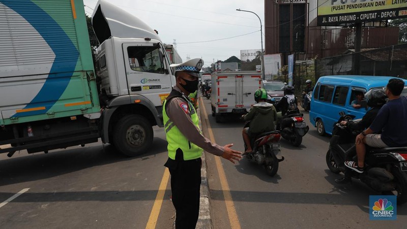 Truk bermuatan mengangkut ribuan karton Minyak Kita terjeblos, di  Jalan Raya Parung - Ciputat, Bojongsari Depok, Jawa Barat, Rabu, (10/1/2023). (CNBC Indonesia/Muhammad Sabki)