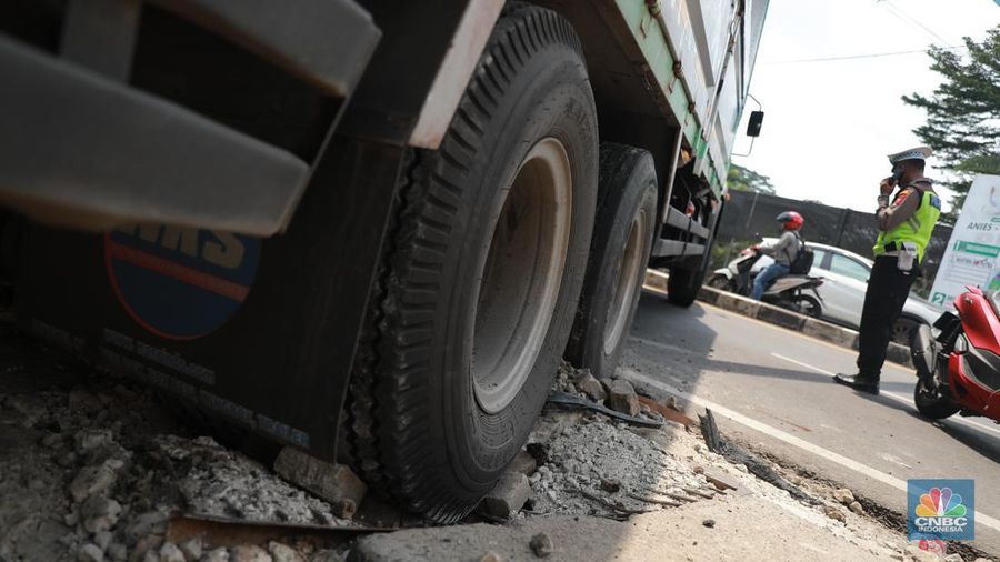 Truk bermuatan mengangkut ribuan karton Minyak Kita terjeblos, di  Jalan Raya Parung - Ciputat, Bojongsari Depok, Jawa Barat, Rabu, (10/1/2023). (CNBC Indonesia/Muhammad Sabki)