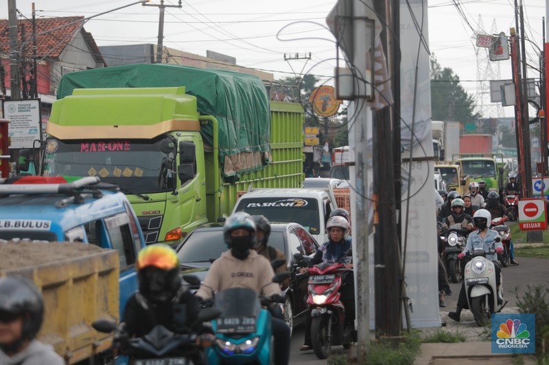 Truk bermuatan mengangkut ribuan karton Minyak Kita terjeblos, di  Jalan Raya Parung - Ciputat, Bojongsari Depok, Jawa Barat, Rabu, (10/1/2023). (CNBC Indonesia/Muhammad Sabki)