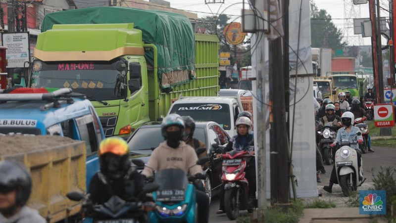 Truk bermuatan mengangkut ribuan karton Minyak Kita terjeblos, di  Jalan Raya Parung - Ciputat, Bojongsari Depok, Jawa Barat, Rabu, (10/1/2023). (CNBC Indonesia/Muhammad Sabki)
