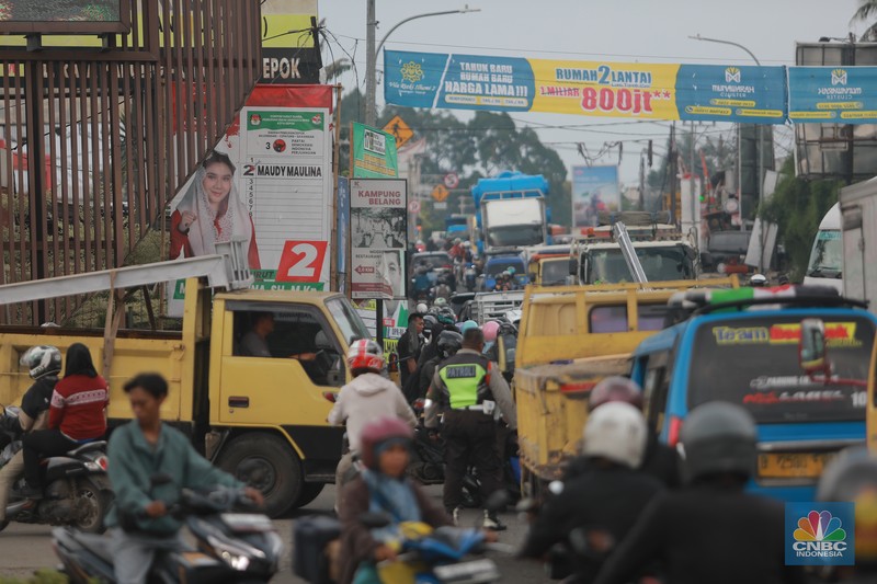 Truk bermuatan mengangkut ribuan karton Minyak Kita terjeblos, di  Jalan Raya Parung - Ciputat, Bojongsari Depok, Jawa Barat, Rabu, (10/1/2023). (CNBC Indonesia/Muhammad Sabki)