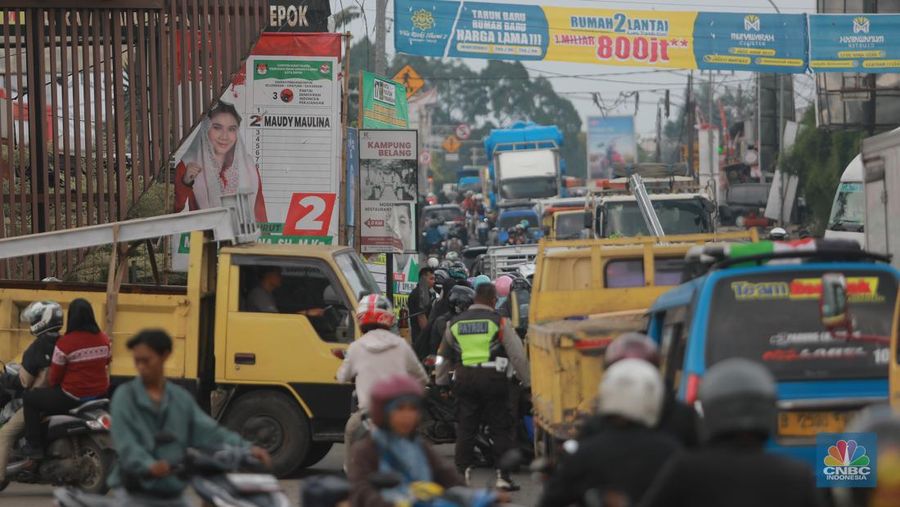 Truk bermuatan mengangkut ribuan karton Minyak Kita terjeblos, di  Jalan Raya Parung - Ciputat, Bojongsari Depok, Jawa Barat, Rabu, (10/1/2023). (CNBC Indonesia/Muhammad Sabki)