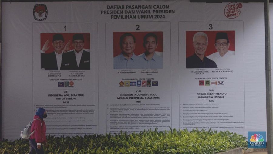 Warga melintas di samping baliho sosialisasi visi dan misi tiga pasangan calon presiden dan wakil presiden 2024 yang terpasang di kawasan Kuningan, Jakarta, Rabu (10/1/2024). Baliho sosialisasi tersebut bertujuan untuk mengedukasi masyarakat agar mengetahui visi dan misi ketiga paslon capres-cawapres 2024. (²©²ÊÍøÕ¾/Muhammad Sabki)