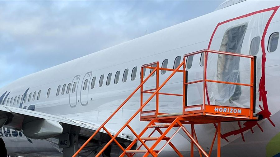 Petugas memeriksa area pintu badan pesawat Alaska Airlines Penerbangan 1282 Boeing 737-9 MAX, yang terlepas dan pesawat melakukan pendaratan darurat, (8/1/2024). (via REUTERS/NTSB)