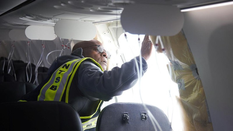 Petugas memeriksa area pintu badan pesawat Alaska Airlines Penerbangan 1282 Boeing 737-9 MAX, yang terlepas dan pesawat melakukan pendaratan darurat, (8/1/2024). (via REUTERS/NTSB)