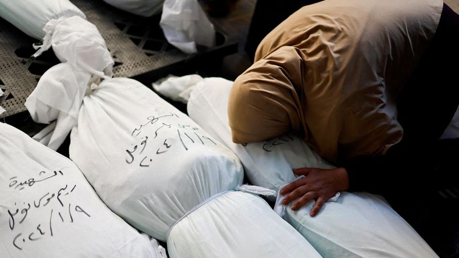 Seorang pelayat bereaksi di samping jenazah warga Palestina yang tewas dalam serangan Israel, di tengah konflik yang sedang berlangsung antara Israel dan kelompok Islam Palestina Hamas, di Rafah, di selatan Jalur Gaza, 10 Januari 2024. (REUTERS/Mohammed Salem)