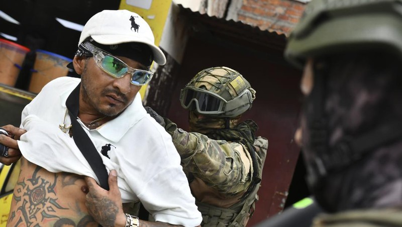 Seorang tentara memeriksa punggung seorang pria, memeriksa tato geng, selama operasi penghentian dan penggeledahan di Portoviejo, Ekuador, Kamis, 11 Januari 2024. Presiden Daniel Noboa pada Senin menetapkan keadaan darurat nasional karena gelombang kejahatan, sebuah tindakan yang memungkinkan pihak berwenang menangguhkan hak-hak masyarakat dan memobilisasi militer.  (AP Photo/Ariel Ochoa)