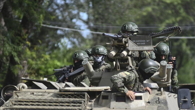 Seorang tentara memeriksa punggung seorang pria, memeriksa tato geng, selama operasi penghentian dan penggeledahan di Portoviejo, Ekuador, Kamis, 11 Januari 2024. Presiden Daniel Noboa pada Senin menetapkan keadaan darurat nasional karena gelombang kejahatan, sebuah tindakan yang memungkinkan pihak berwenang menangguhkan hak-hak masyarakat dan memobilisasi militer.  (AP Photo/Ariel Ochoa)