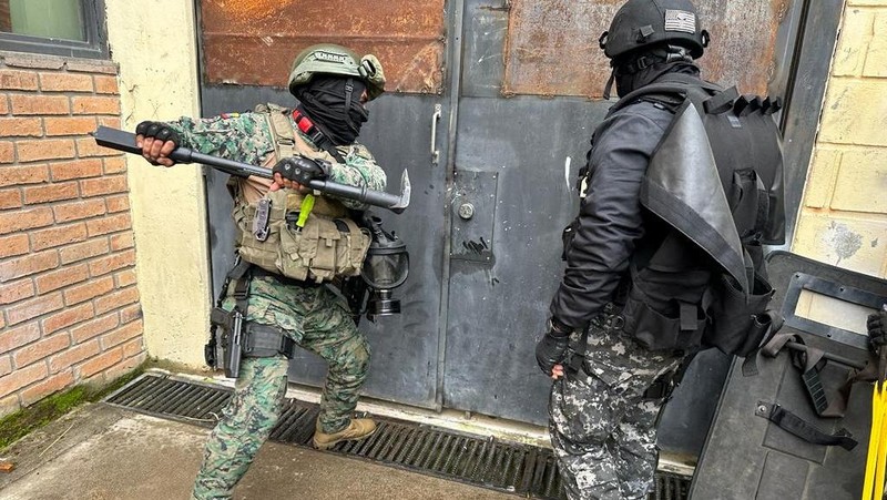 Anggota militer berjalan di luar penjara, ketika angkatan bersenjata Ekuador memasuki penjara di seluruh negeri dalam upaya memulihkan ketertiban setelah pembebasan penjaga penjara dan staf lain yang disandera, di Cotopaxi, Ekuador, 14 Januari 2024. (REUTERS/Karen Toro)