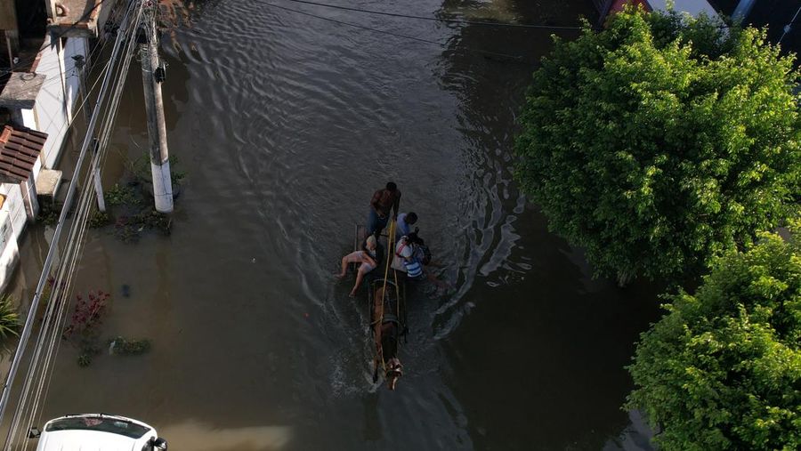 Pemandangan udara dari seekor kuda yang membawa orang-orang menyusuri jalan yang banjir, setelah hujan lebat melanda Duque de Caxias di negara bagian Rio de Janeiro, Brasil, 15 Januari 2024. (REUTERS/Pilar Olivares)