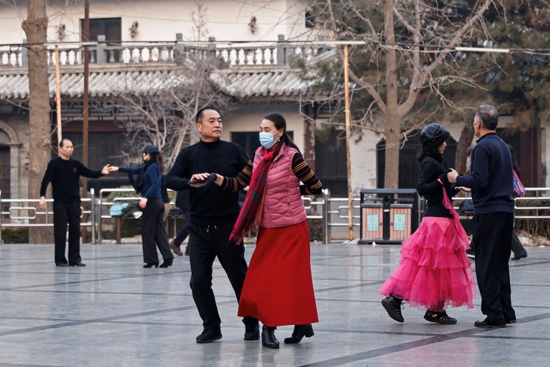 Seorang wanita dan seorang anak duduk di sebuah taman di Beijing, Cina 12 Januari 2024. (REUTERS/Tingshu Wang)