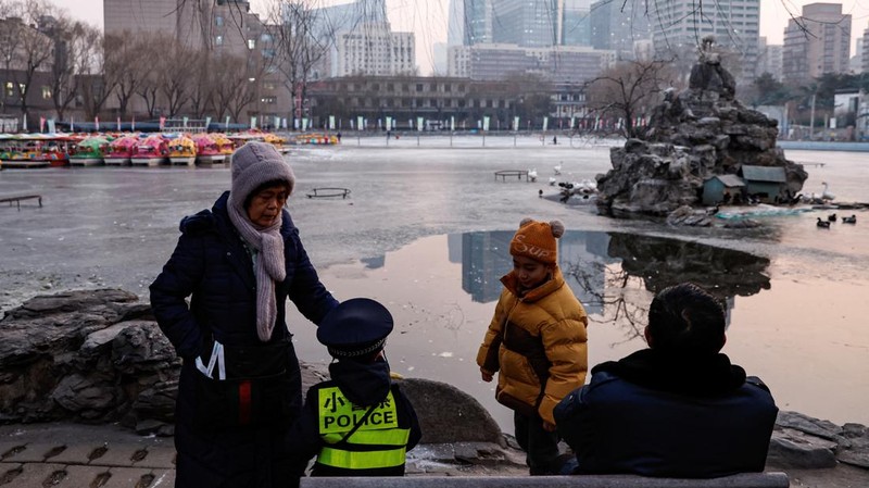 Seorang wanita dan seorang anak duduk di sebuah taman di Beijing, Cina 12 Januari 2024. (REUTERS/Tingshu Wang)