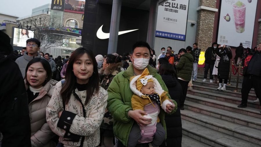 Seorang pria menggendong seorang anak di sebuah pusat perbelanjaan di Beijing, 30 Desember 2023. Populasi Tiongkok turun 2 juta orang pada tahun 2023, penurunan tahunan kedua berturut-turut seiring dengan menurunnya angka kelahiran dan melonjaknya angka kematian. (AP Photo/Ng Han Guan)