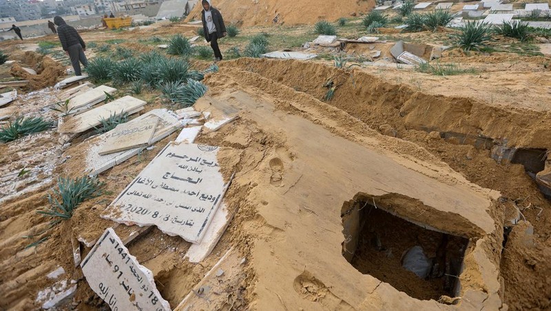 Seorang pria Palestina memeriksa kuburan yang rusak di pemakaman setelah serangan Israel, di tengah konflik yang sedang berlangsung antara Israel dan kelompok Islam Palestina Hamas, di Khan Younis di selatan Jalur Gaza, 17 Januari 2024. (REUTERS/Ahmed Zakot)