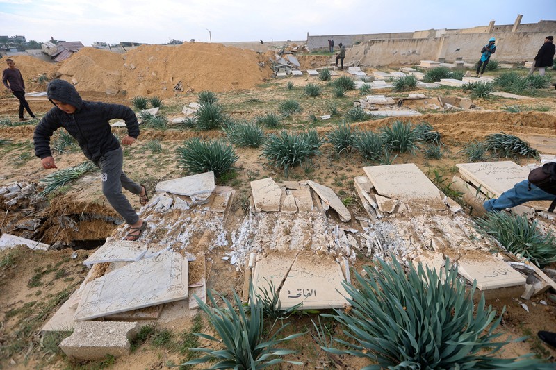 Seorang pria Palestina memeriksa kuburan yang rusak di pemakaman setelah serangan Israel, di tengah konflik yang sedang berlangsung antara Israel dan kelompok Islam Palestina Hamas, di Khan Younis di selatan Jalur Gaza, 17 Januari 2024. Seorang pria Palestina memeriksa kuburan yang rusak di pemakaman setelah serangan Israel, di tengah konflik yang sedang berlangsung antara Israel dan kelompok Islam Palestina Hamas, di Khan Younis di selatan Jalur Gaza, 17 Januari 2024. (REUTERS/Ahmed Zakot)