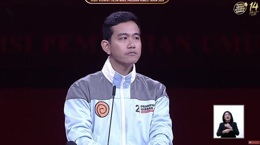 Calon wakil presiden (Cawapres) Gibran Rakabuming Raka tampak memakai jaket bertuliskan Samsul dalam debat keempat calon wakil presiden Pemilu 2024 di JCC, Jakarta, Minggu, (21/1/2024). (Tangkapan Layar Youtube KPU RI)