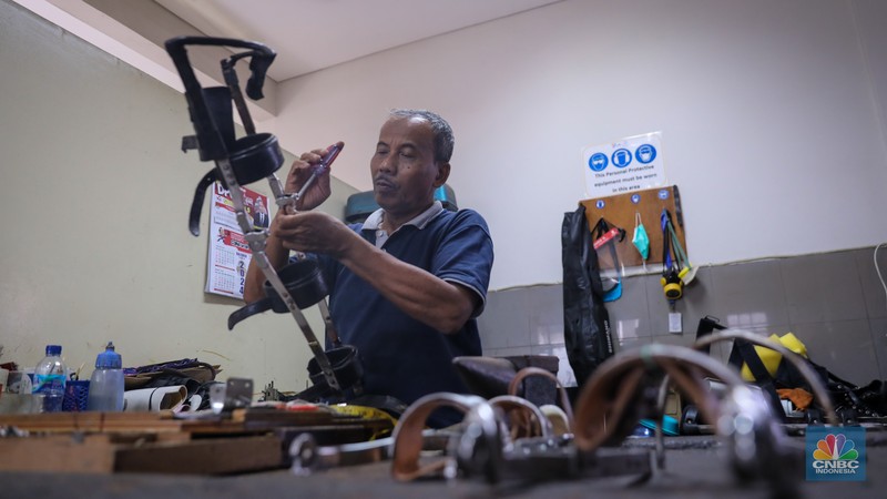 Pekerja menyelesaikan pembuatan sepatu penyangga untuk penyandang disabilitas milik Unit Ortotik pada salah satu Yayasan di Jakarta, Senin (22/1/2024). (CNBC Indonesia/Faisal Rahman)