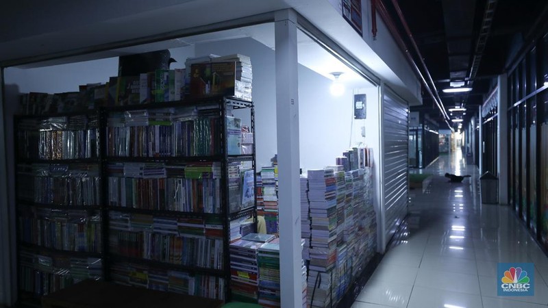 Seorang warga melewati lorong-lorong toko yang sepi di Pasar Buku Kenari, Jakarta, Senin (22/1/2024). Pasar buku di Kenari yang bernama Jakbook sepi sejak diresmikan Anies Baswedan pada April 2019 lalu. Pedagang menyiasati kondisi itu dengan berjualan online. (վ/Tri Susilo)