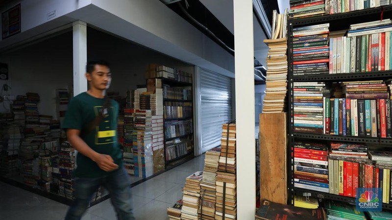 Seorang warga melewati lorong-lorong toko yang sepi di Pasar Buku Kenari, Jakarta, Senin (22/1/2024). Pasar buku di Kenari yang bernama Jakbook sepi sejak diresmikan Anies Baswedan pada April 2019 lalu. Pedagang menyiasati kondisi itu dengan berjualan online. (վ/Tri Susilo)