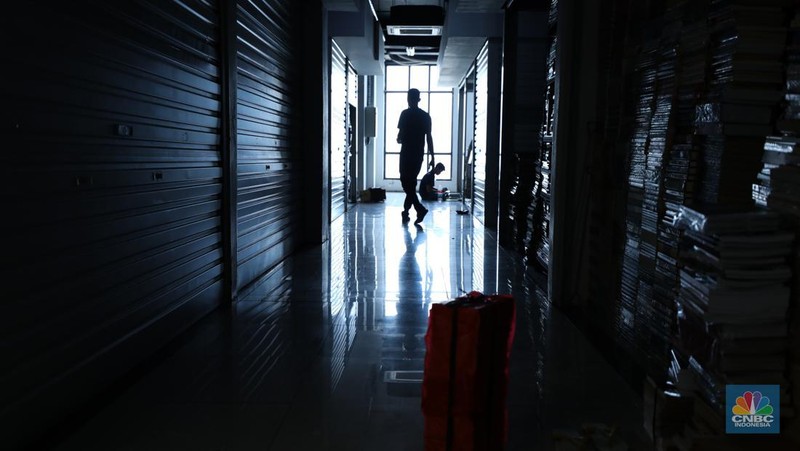 Seorang warga melewati lorong-lorong toko yang sepi di Pasar Buku Kenari, Jakarta, Senin (22/1/2024). Pasar buku di Kenari yang bernama Jakbook sepi sejak diresmikan Anies Baswedan pada April 2019 lalu. Pedagang menyiasati kondisi itu dengan berjualan online. (վ/Tri Susilo)
