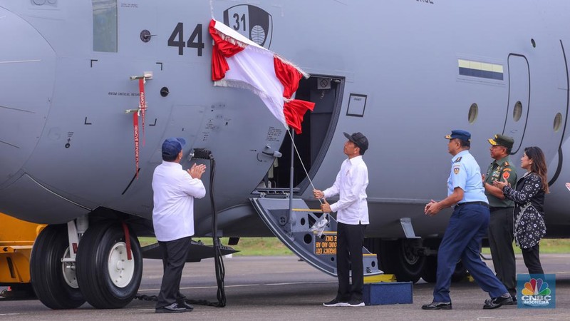 Presiden Joko Widodo didampingi Menter Pertahanan Prabowo Subianto menarik tirai merah putih saat menghadiri penyerahaan pesawat C-130J A-1344 Super Hercules, helikopter AS-550 Fennec, dan helikopter AS-565 dari Kementerian Pertahanan (Kemhan) ke TNI AU di Terminal Selatan Lanud Halim Perdanakusuma, Jakarta, Rabu (23/1/2024). (CNBC Indonesia/Faisal Rahman)