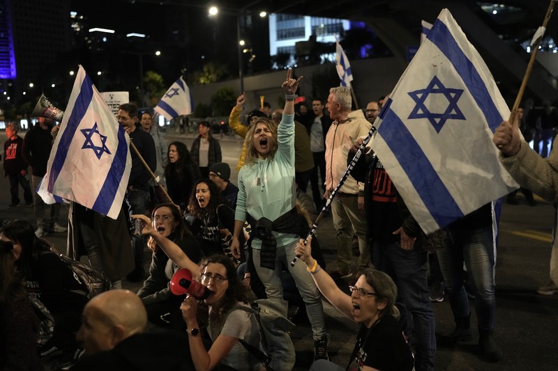 Sekelompok keluarga sandera dan pengunjuk rasa memblokir lalu lintas di luar kediaman pribadi Perdana Menteri Israel Benjamin Netanyahu di Jalan Azza di Yerusalem. (AP/Leo Correa)