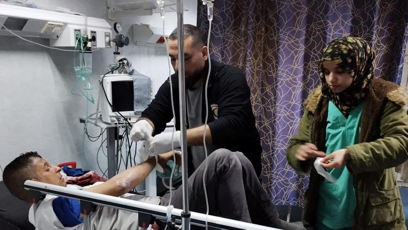 Seorang pria Palestina yang terluka menerima bantuan medis di Rumah Sakit Al-Amal, di tengah konflik yang sedang berlangsung antara Israel dan kelompok Islam Palestina Hamas, di Khan Younis, Jalur Gaza, dalam gambar selebaran yang dirilis pada 23 Januari 2024. (Palestine Red Crescent Society/Volunteer Ameer Abu Aisha/Handout via REUTERS)
