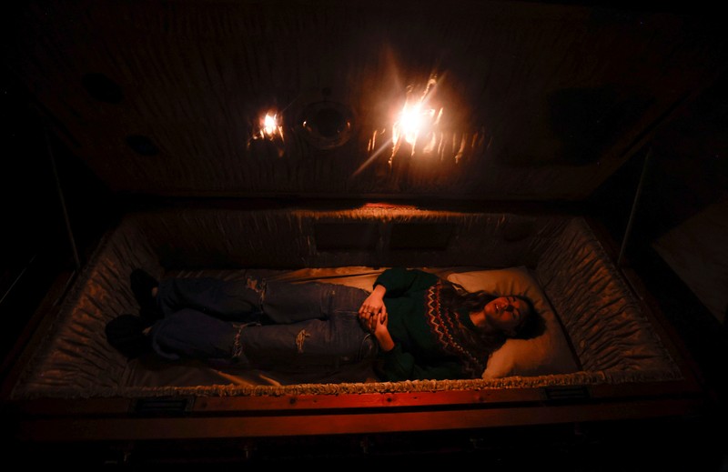 A couple of gamers, Miriam Castella and Carlos Granedo, participate in an extreme escape room named Catalepsia, which takes place inside two coffins simulating their funeral and trying to escape from them by working in pairs to solve puzzles and tricks, in Barcelona, Spain, January 18, 2024. REUTERS/ Albert Gea