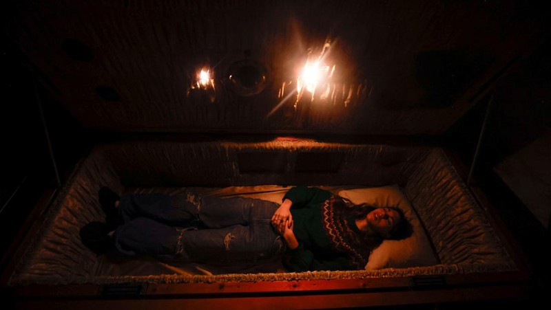 A couple of gamers, Miriam Castella and Carlos Granedo, participate in an extreme escape room named Catalepsia, which takes place inside two coffins simulating their funeral and trying to escape from them by working in pairs to solve puzzles and tricks, in Barcelona, Spain, January 18, 2024. REUTERS/ Albert Gea