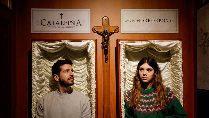 A couple of gamers, Miriam Castella and Carlos Granedo, participate in an extreme escape room named Catalepsia, which takes place inside two coffins simulating their funeral and trying to escape from them by working in pairs to solve puzzles and tricks, in Barcelona, Spain, January 18, 2024. REUTERS/ Albert Gea