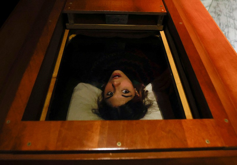 A couple of gamers, Miriam Castella and Carlos Granedo, participate in an extreme escape room named Catalepsia, which takes place inside two coffins simulating their funeral and trying to escape from them by working in pairs to solve puzzles and tricks, in Barcelona, Spain, January 18, 2024. REUTERS/ Albert Gea
