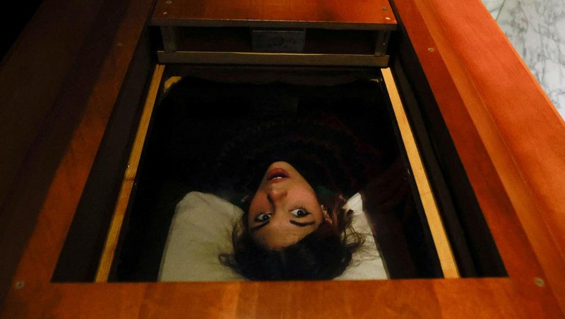 A couple of gamers, Miriam Castella and Carlos Granedo, participate in an extreme escape room named Catalepsia, which takes place inside two coffins simulating their funeral and trying to escape from them by working in pairs to solve puzzles and tricks, in Barcelona, Spain, January 18, 2024. REUTERS/ Albert Gea
