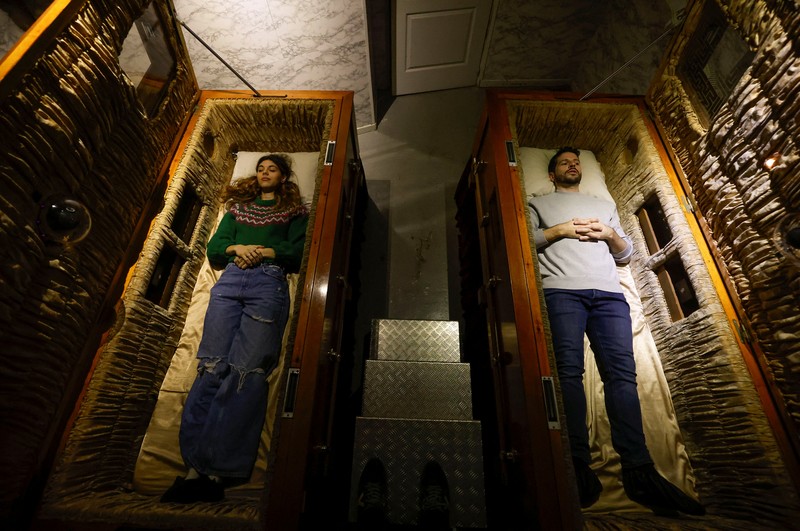A couple of gamers, Miriam Castella and Carlos Granedo, participate in an extreme escape room named Catalepsia, which takes place inside two coffins simulating their funeral and trying to escape from them by working in pairs to solve puzzles and tricks, in Barcelona, Spain, January 18, 2024. REUTERS/ Albert Gea