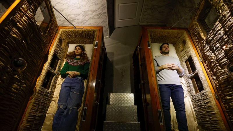 A couple of gamers, Miriam Castella and Carlos Granedo, participate in an extreme escape room named Catalepsia, which takes place inside two coffins simulating their funeral and trying to escape from them by working in pairs to solve puzzles and tricks, in Barcelona, Spain, January 18, 2024. REUTERS/ Albert Gea