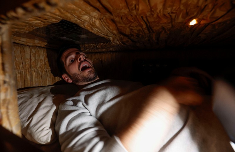 A couple of gamers, Miriam Castella and Carlos Granedo, participate in an extreme escape room named Catalepsia, which takes place inside two coffins simulating their funeral and trying to escape from them by working in pairs to solve puzzles and tricks, in Barcelona, Spain, January 18, 2024. REUTERS/ Albert Gea