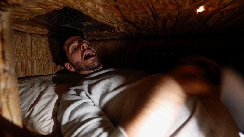 A couple of gamers, Miriam Castella and Carlos Granedo, participate in an extreme escape room named Catalepsia, which takes place inside two coffins simulating their funeral and trying to escape from them by working in pairs to solve puzzles and tricks, in Barcelona, Spain, January 18, 2024. REUTERS/ Albert Gea