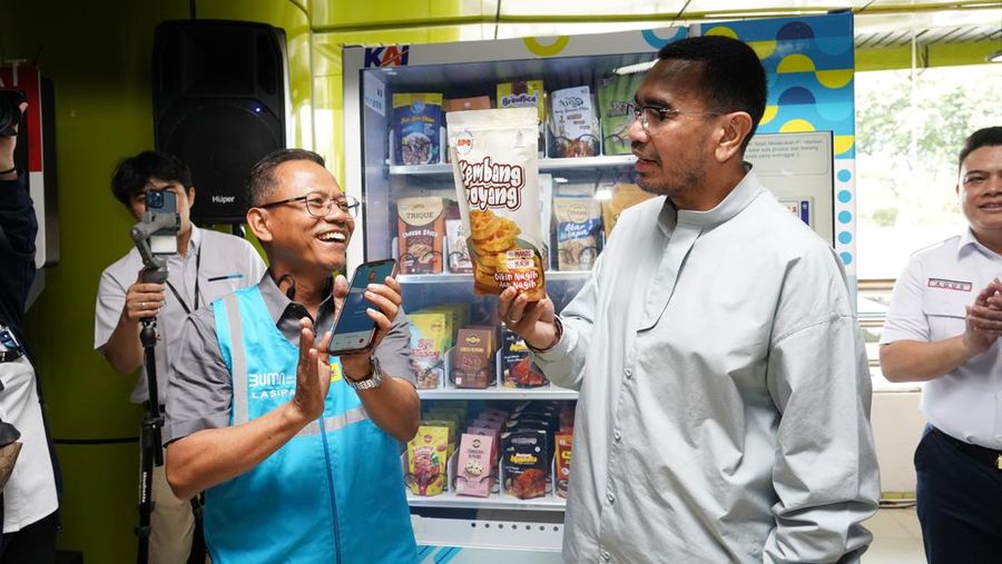 Staf Khusus III Menteri BUMN, Arya Sinulingga (kanan) membeli produk UMKM di vending machine didampingi General Manager PLN Unit Induk Distribusi Jakarta Raya, Lasiran (kiri)