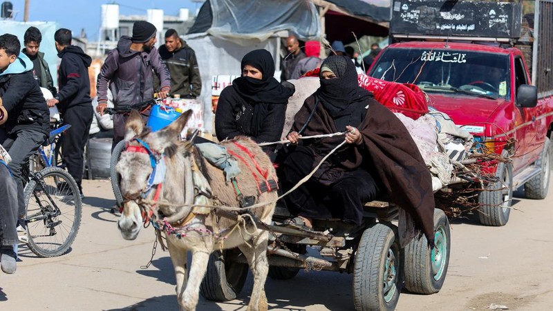 Warga Palestina yang melarikan diri dari Khan Younis, akibat operasi darat Israel, di tengah konflik yang sedang berlangsung antara Israel dan kelompok Islam Palestina Hamas, bergerak menuju Rafah, di selatan Jalur Gaza, 25 Januari 2024. (REUTERS/Ibraheem Abu Mustafa)